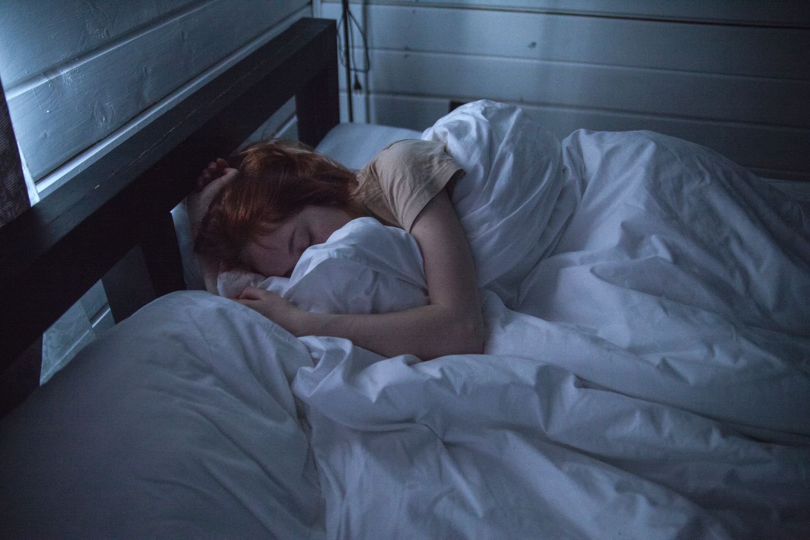A person sleeping in a softly lit bedroom