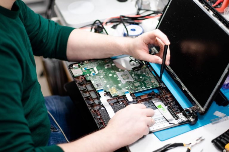 A technician repairing an electronic device at a workbench