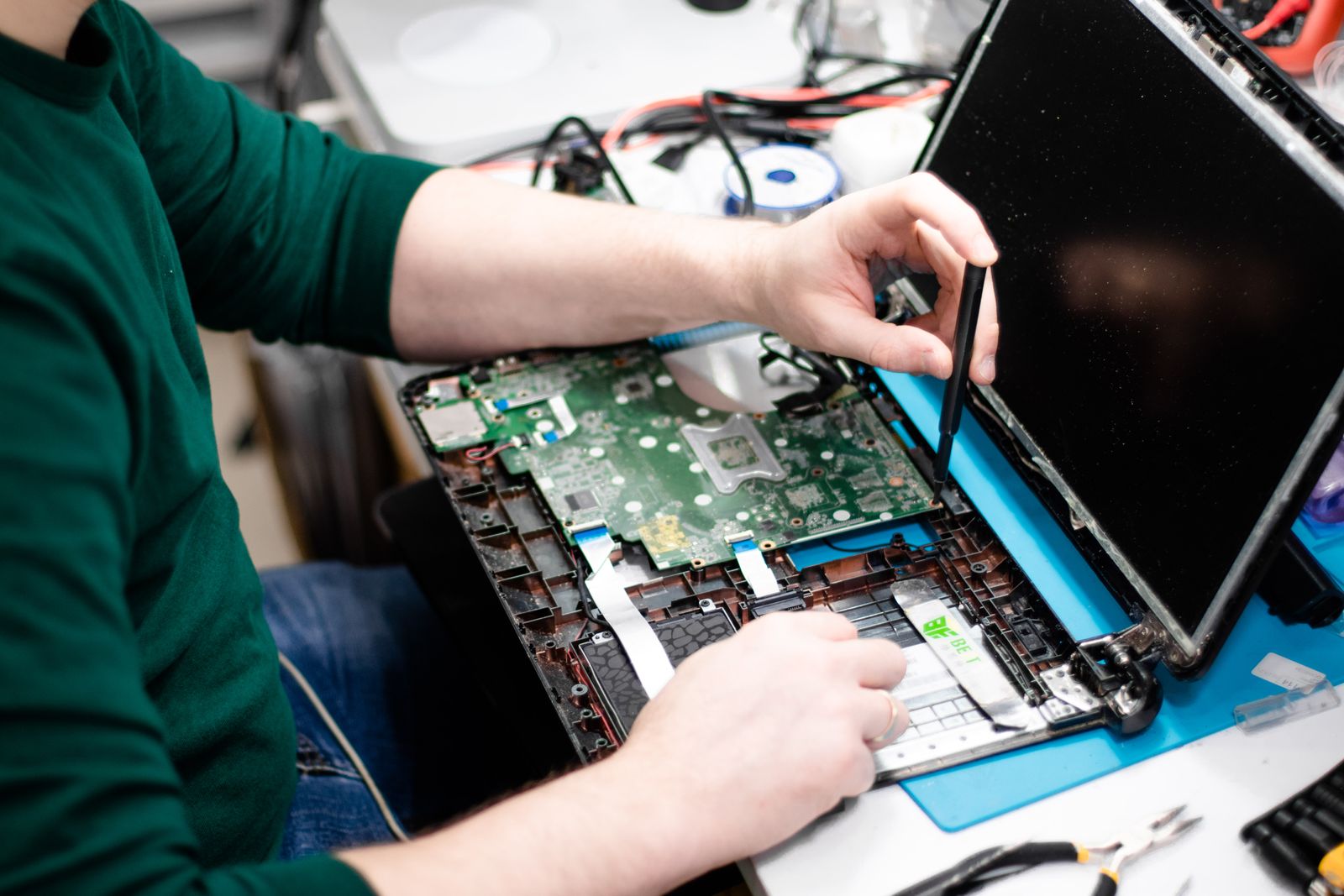 A technician repairing an electronic device at a workbench
