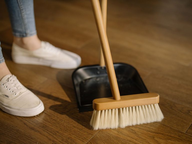 A robot vacuum moving across a wooden floor