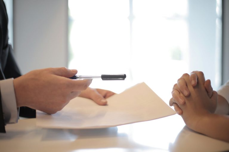 A reader examining a document carefully at a desk